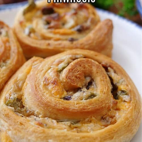 A close up of jalapeno popper pinwheels on a white plate with blue trim.