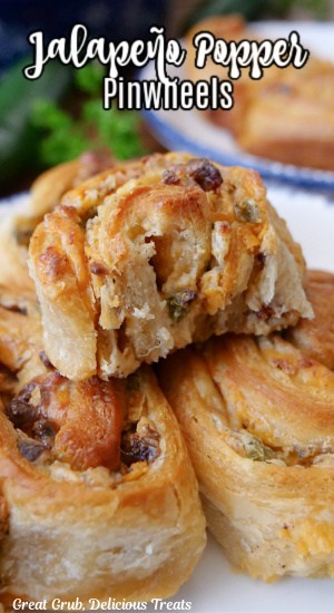 Three crescent pinwheels filled with jalapeno popper ingredients, and one with a bite out of it.