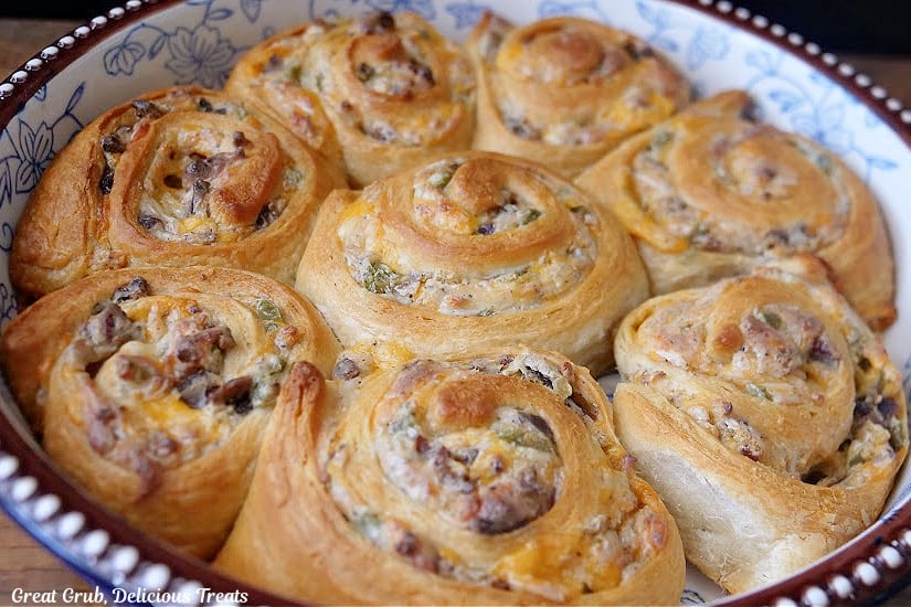 A deep dish pie plate with eight jalapeno popper pinwheels after being baked.
