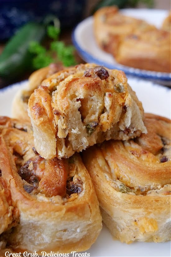 A few jalapeno popper pinwheels on a white plate with a bite taken out of one of them.