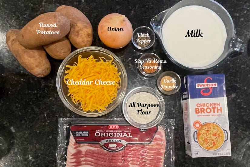 A black granite surface with all the ingredients to make loaded baked potato soup on it.