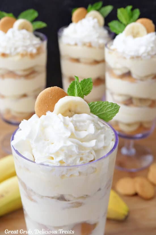 A close up of a banana parfait with three more in the background.