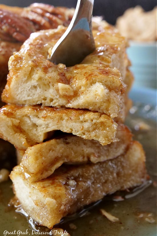 Maple Pecan French Toast is an easy breakfast recipe to make no matter how big the crowd. A fork pushed down into the center of a big bite of French toast.