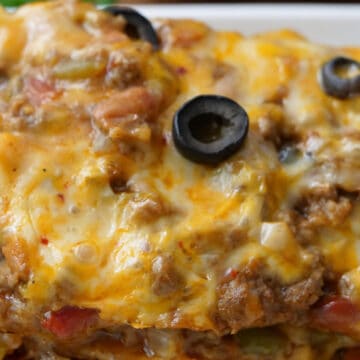A close up of a serving of Mexican Lasagna on a white plate.