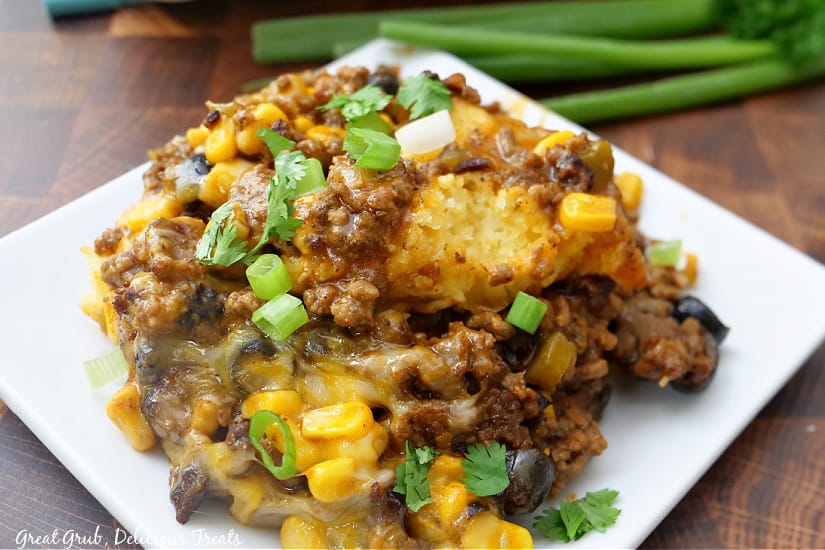 A white square plate with a serving of tamale pie on it.