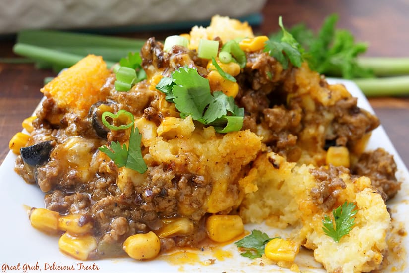 A horizontal photo of a white plate with a serving of Mexican Tamale Pie on it.