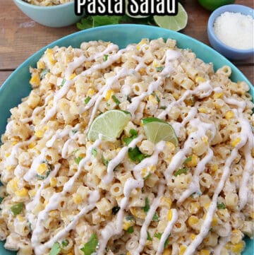 A large blue bowl filled with pasta salad and drizzled with street corn dressing.