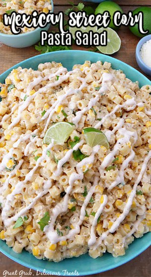 Mexican Street Corn Pasta Salad is an easy and simple pasta salad recipe with all of the flavors of street corn. An overhead photo of a large bowl of pasta salad with wedges of lime on top.