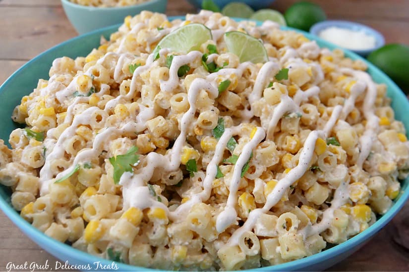 Mexican Street Corn Pasta Salad is a flavorful pasta salad that is loaded with fresh corn, cilantro, and a street corn dressing. A landscape photo of a bowl of pasta salad loaded with pasta, corn, cilantro, and a street corn dressing.