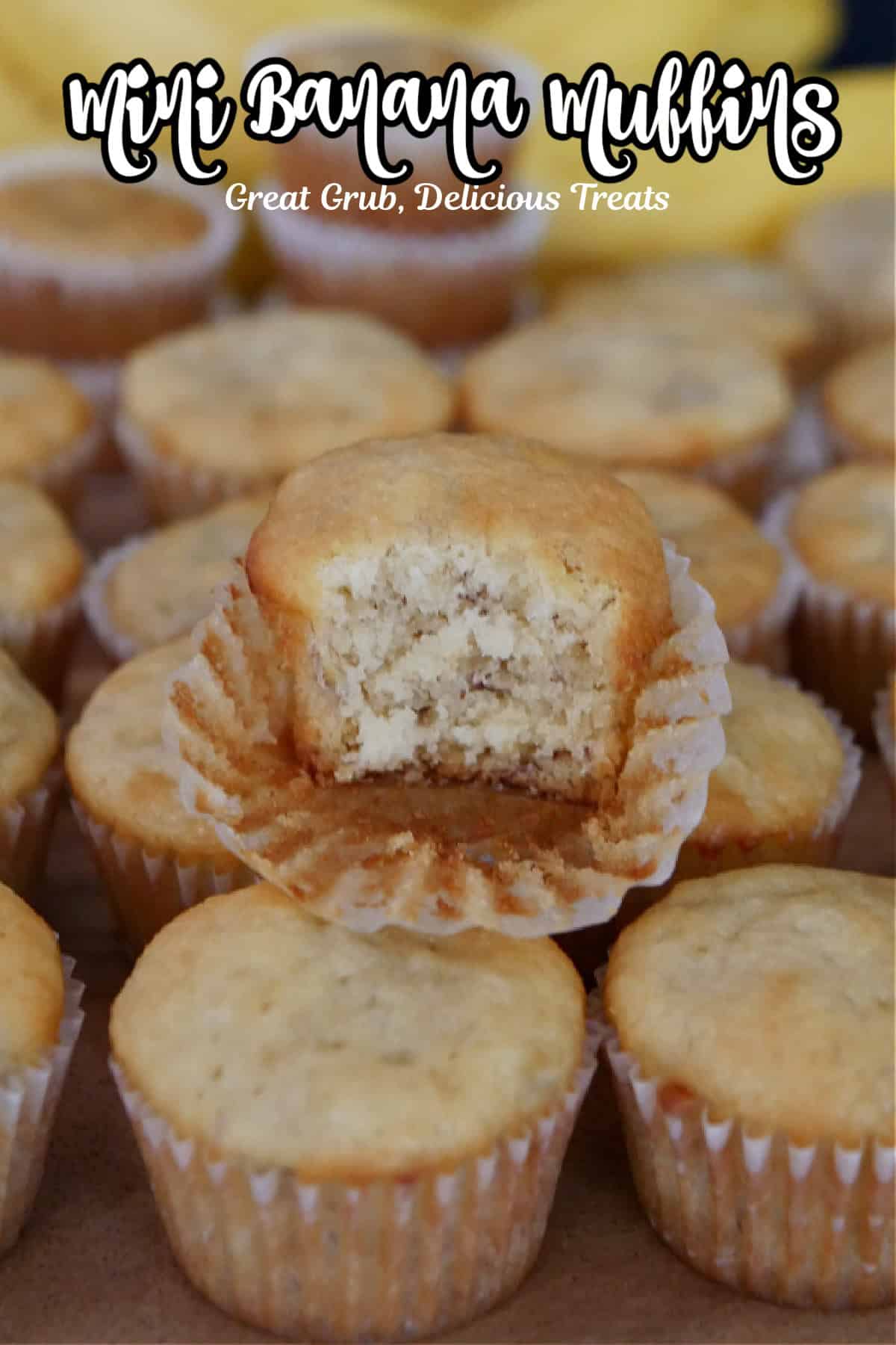 Bite size banana muffins place on a hard surface with a bite taken out of one of the muffins on top.