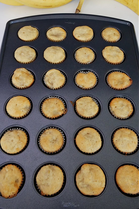 A mini muffin pan with baked mini banana muffins in it.