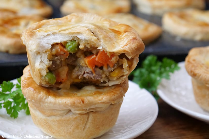 A horizontal photo of mini pot pies with a bite taken out of one of them.