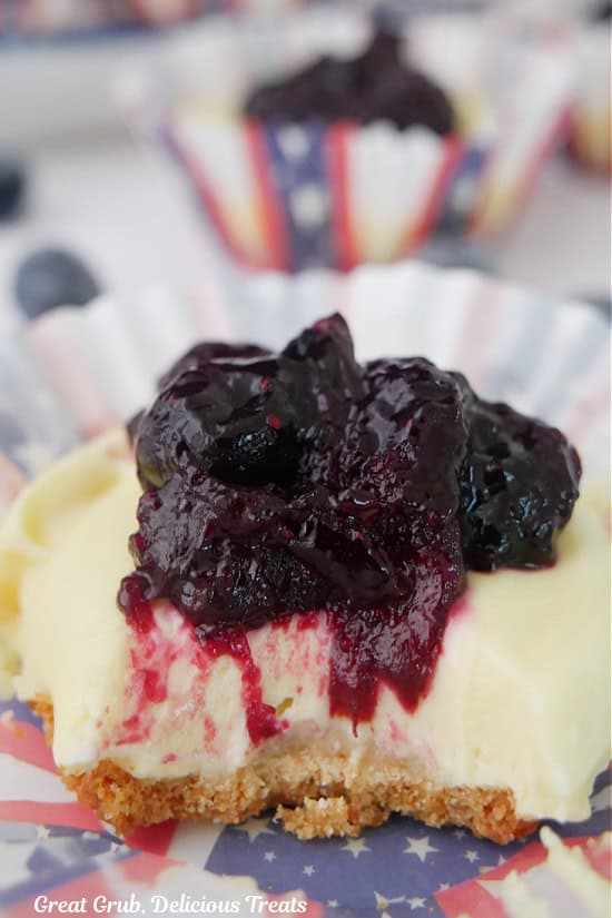 A red white and blue cupcake liner with a mini blueberry lemonade pie in it and the wrapper is pulled down around the pie.