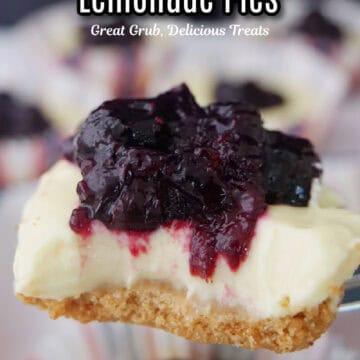 A mini blueberry lemonade pie held above other mini pies with a bite taken out of it.
