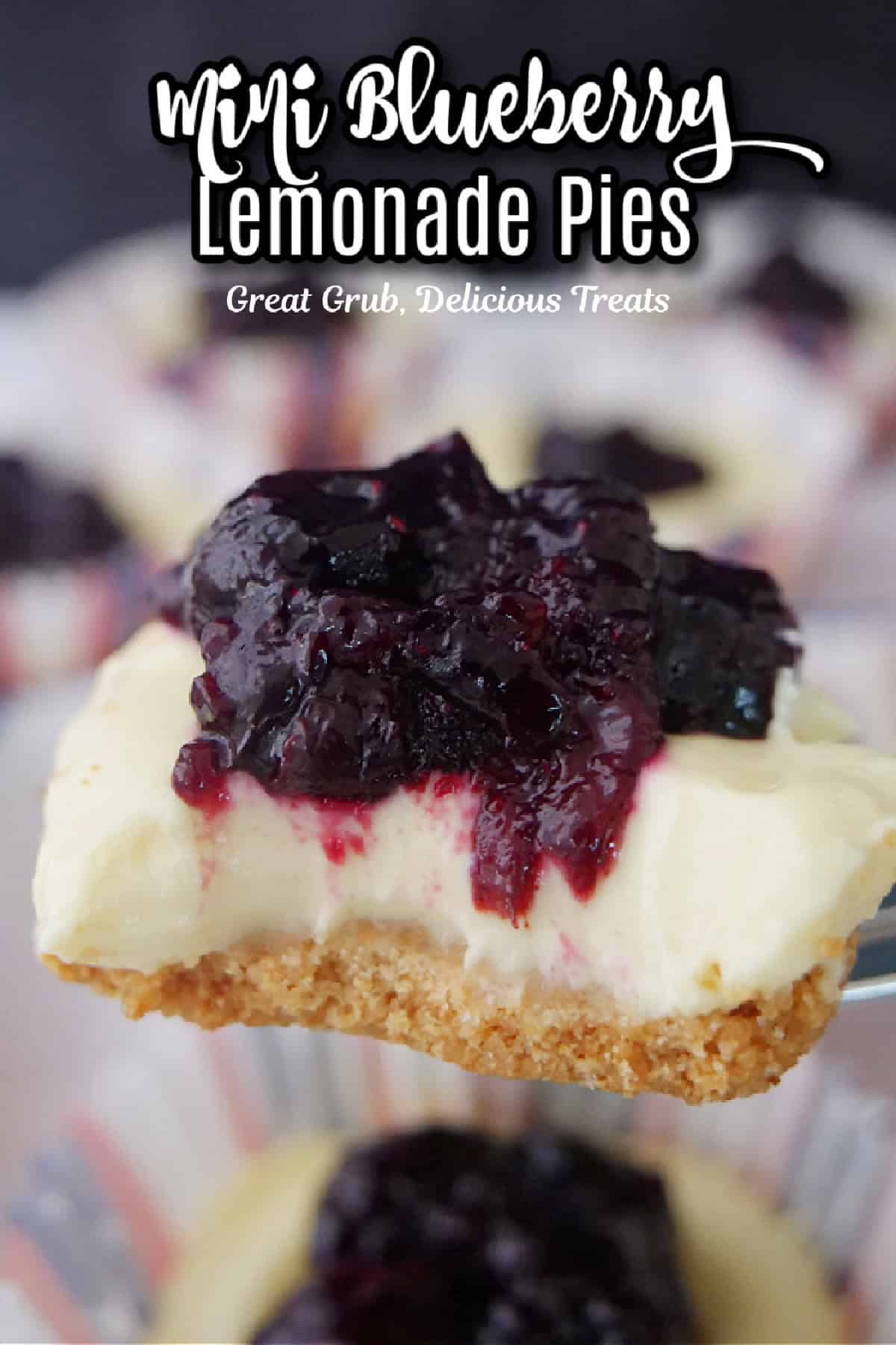 A mini blueberry lemonade pie held above other mini pies with a bite taken out of it.