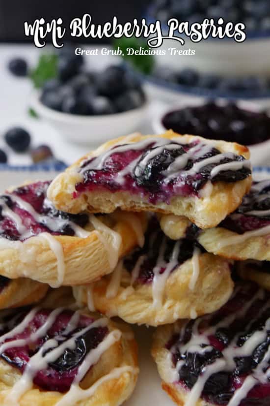 A small stack of mini blueberry pastries with a bite taken out of the pastry on top.