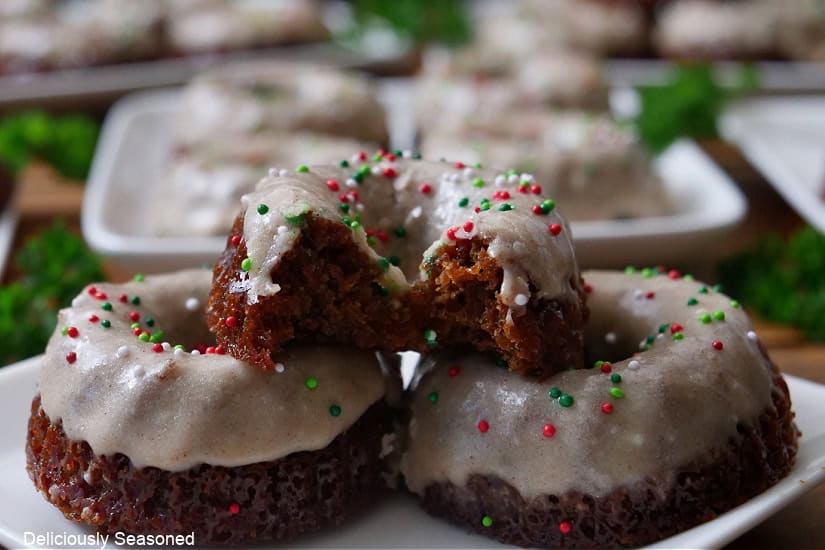A small white plate with three mini gingerbread bundt cakes on it with a bite taken out of the one on top.