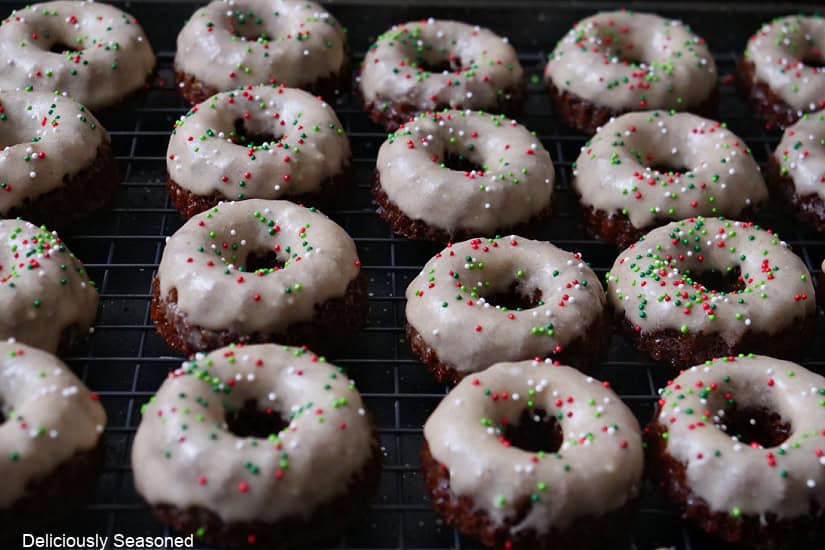 A wire rack with approximately 20 mini bundt cakes on it.