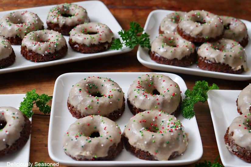 Five white plates with mini gingerbread bundt cakes on them.