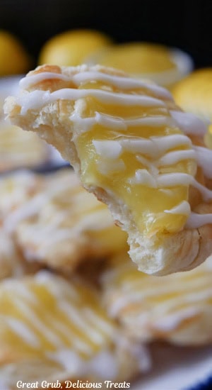A close up of a bite-size lemon pastry with a bite taken out of it.