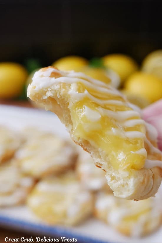 A close up of a min lemon pastry with a big bite taken out of it.