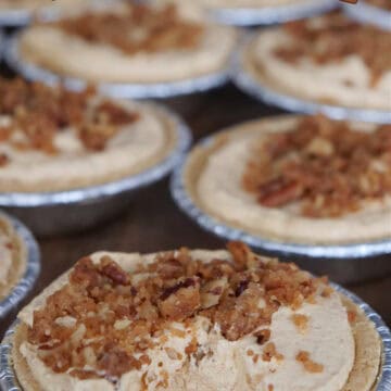 A wood surface with mini pumpkin pies on it with the title of the recipe at the top.