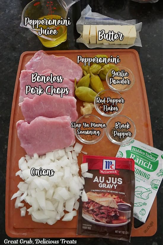 A brown cutting board with all the labeled ingredients needed for Mississippi Pork Chops.