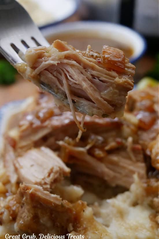 A bite of slow cooked pork chops on a fork.