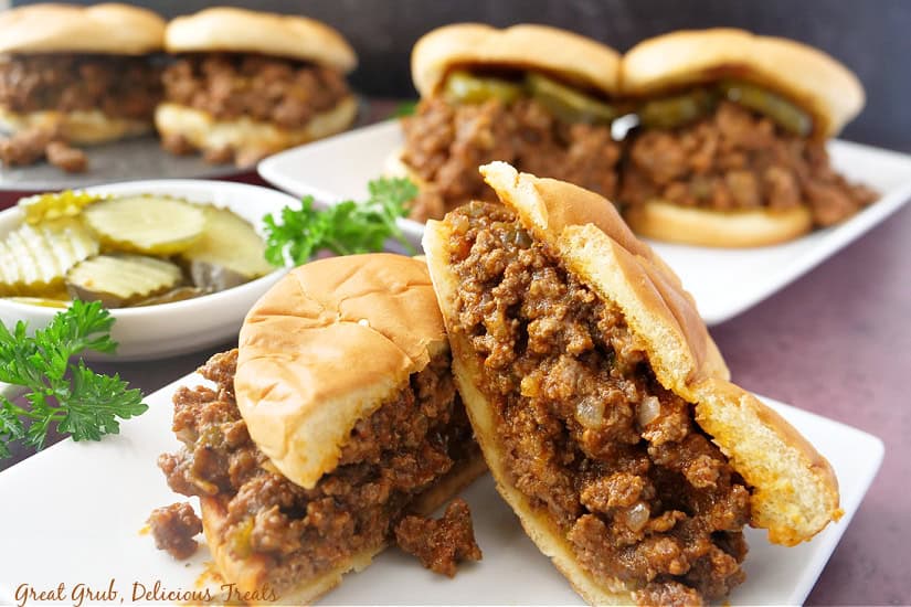 A counter with three plates with sloppy joes on them.