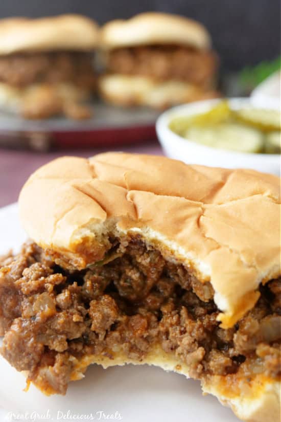 A sloppy joe on a counter with a big bite taken out of it.