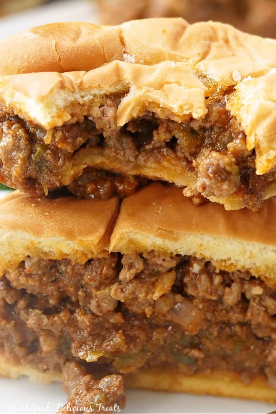 Two half sloppy joes on top of each other with a bite out of the one on top.