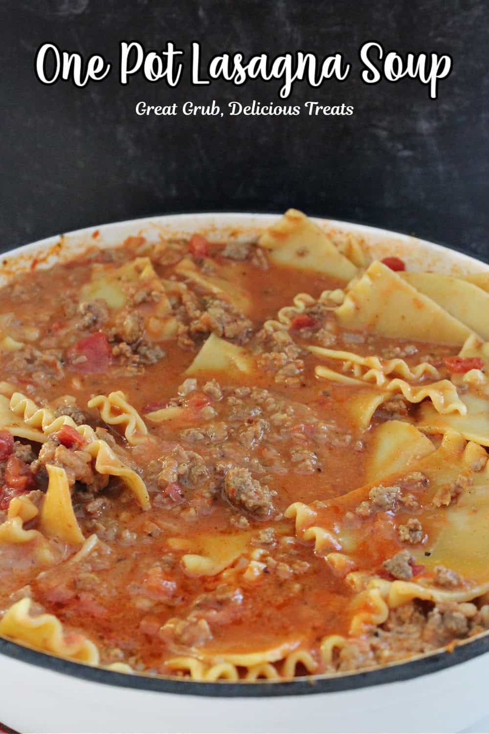 A white cast iron pot filled with lasagna soup, with the title of the recipe in text at the top.