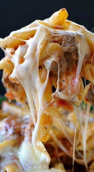 Italian Sausage Penne Casserole A large spoonful of cheesy pasta with Italian sausage on a serving spoon.