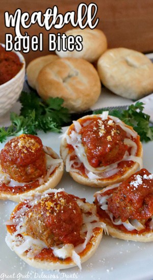 Meatball Bagel Bites are a twist on the classic bagel bites recipe and make a great appetizer recipe. Four Meatball Bagel Bites on a white plate with parsley in the background, a white bowl filled with cooked meatballs in tomato sauce, and a white plate with stacked plain bagels, with the title in the top left corner.