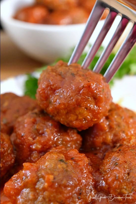 Homemade Italian Meatballs are definitely a favorite Italian meatball recipe the whole family will love. A stack of meatballs with a fork in one of them.
