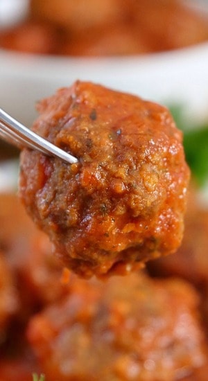 Homemade Italian Meatballs are a delicious game day appetizer recipe the whole team will love. A close up of a homemade meatball on a fork.