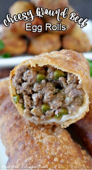 Cheesy Ground Beef Egg Rolls are a delicious appetizer recipe with each egg roll is packed with deliciously seasoned ground beef, cheese and fried to perfection. A close up photo of an egg roll with a bite taken out showing the meat mixture inside.