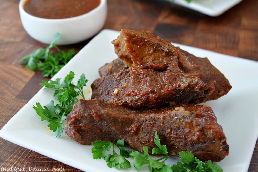 Crock Pot Texas Style Boneless Beef Ribs are tender, savory, slow cooked ribs, made with a homemade BBQ sauce. 4 Crock Pot Texas Style Boneless Beef Ribs on a white plate.