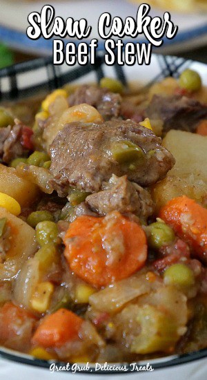 Slow Cooker Beef Stew is hearty, delicious and full of meat, potatoes and vegetables, slow cooked until super tender. A close up photo of beef stew in a black and white colored bowl.