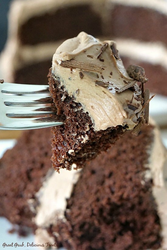 Chocolate Cake with Mocha Mascarpone Frosting is moist, homemade and has the best tasting mocha frosting. A bite of chocolate cake on a fork with the frosting and chocolate shavings on it.