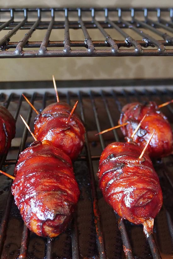 Four smoked armadillo eggs that are still on the smoker after being smoked to perfection.