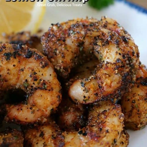 A white plate with seasoned grilled shrimp.