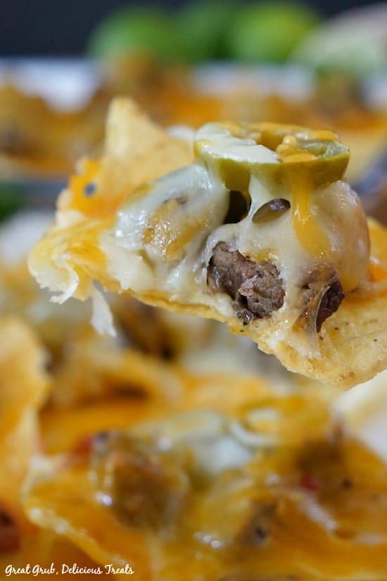 Rib Eye Nachos are loaded with tender leftover rib eye, cheese and topped with sliced jalapenos. Rib Eye Nachos - a tortilla chip with meat, melted cheese and a sliced of jalapeno on top.