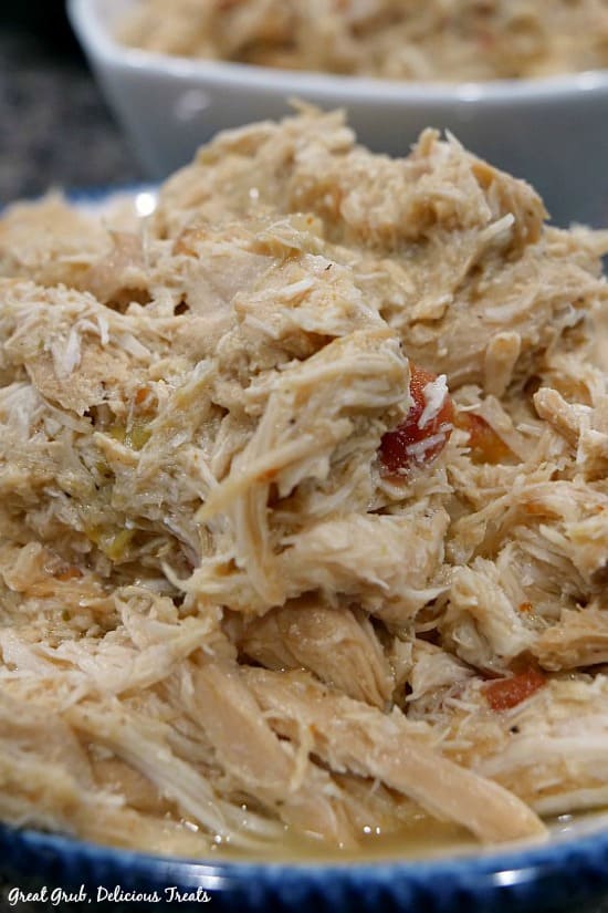 Crock Pot Spicy Chicken is an easy and delicious chicken recipe with delicious flavor. Crock Pot Spicy Chicken- shredded chicken in a white bowl and a bowl with blue trim.
