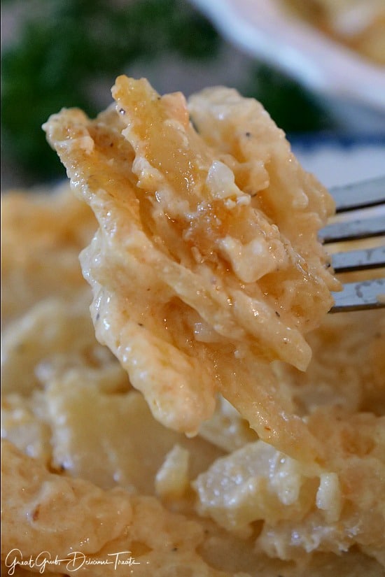 Crock Pot Cheesy Scalloped Potatoes are thin slices of potatoes in a delicious cheesy sauce and cooked in the crock pot. #sidedish #potatorecipes #crockpotmeals #recipes #greatgrubdelicioustreats Crock Pot Cheesy Scalloped Potatoes