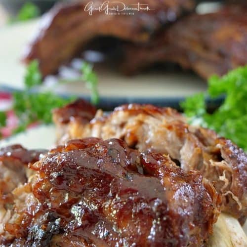 A plate with two BBQ baby back ribs.