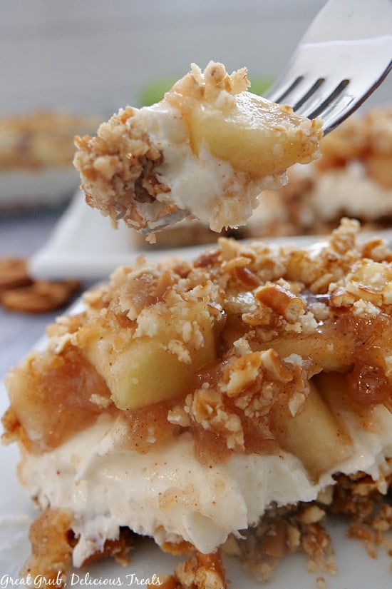 A fork with a bite of apple cinnamon pretzel salad on it.