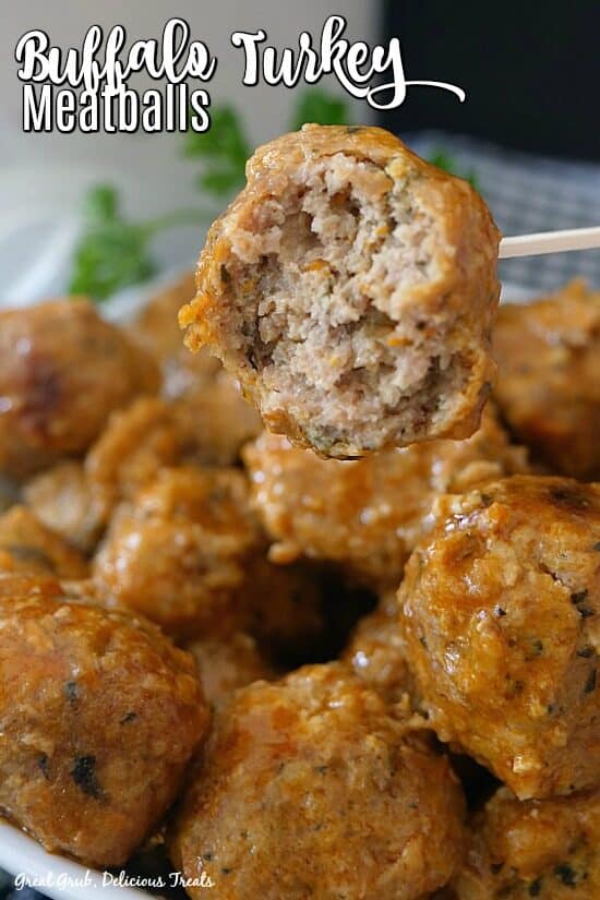 Buffalo Turkey Meatballs are a delicious appetizer recipe that are full of flavor, slow cooked in buffalo sauce, and a family favorite meatball recipe. White bowl full of buffalo turkey meatballs with parsley in the background for decoration.