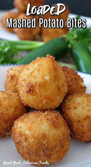 Loaded Mashed Potato Bites are a delicious appetizer recipe and great to make for gatherings and get togethers. Mashed potato balls on a white plate with another plate in the bathroom and jalapeños and cilantro.