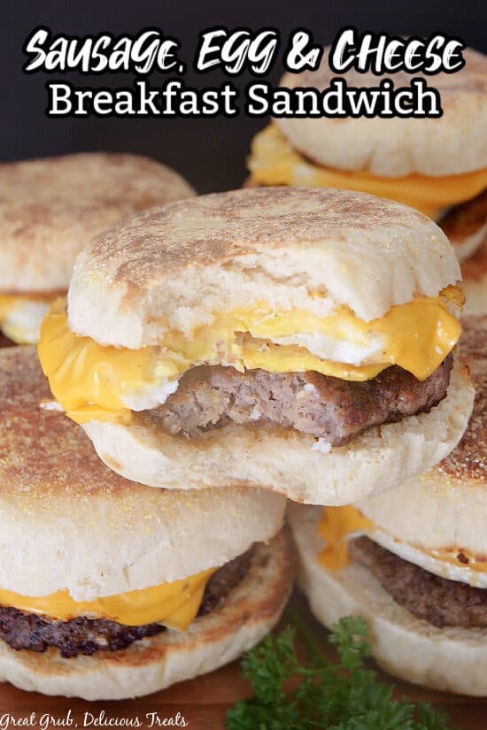 A close up of three breakfast sandwiches stacked on one another, with a bite taken out of one.